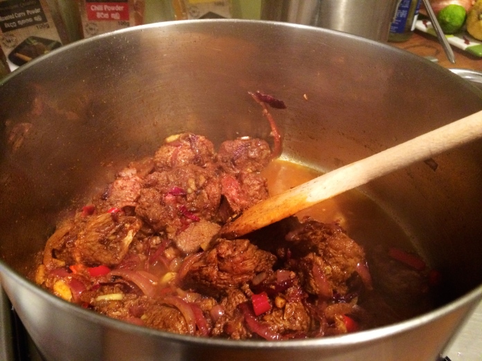 Once the beef pieces have started to brown, add a little bit of the tamarind stock water to loosen up the onion mixture and spices at the bottom of the pan. 