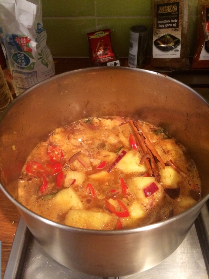 Stir the curry powder and chili powder into the pineapple curry. Add in 4 cloves and 1 dry kaffir lime leaves. 